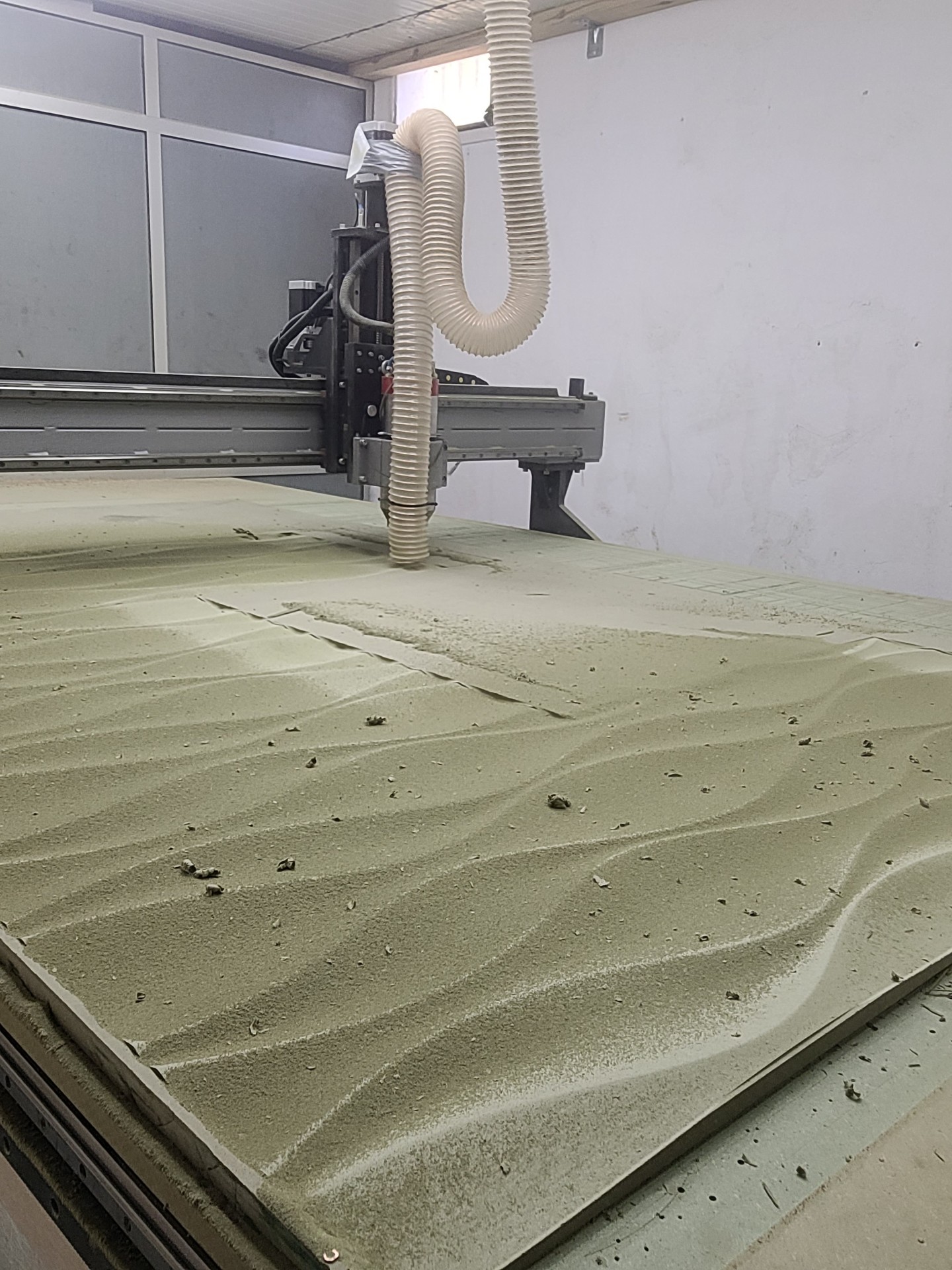Large CNC machine cutting a plywood table top